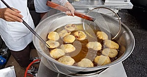 Hawker scooping out cooked Ham Chim Peng from wok, a popular Chinese street food in Malaysia