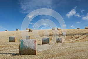 Hay bale harvesting in golden field landscape