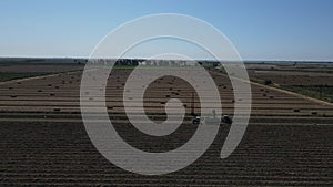 Hay bales in the field and tractor doing work