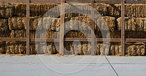 Hay bales are stacked in large stacks forming a wall