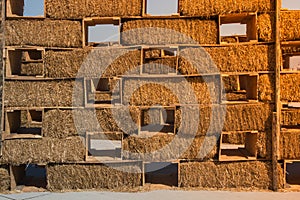 Hay bales are stacked in large stacks forming a wall