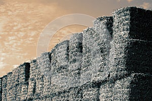 Hay bales stacked on top of each other for animal feed set against sky.