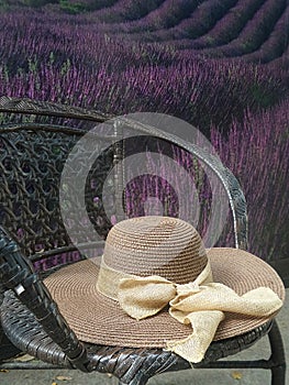 Hay hat and beautiful ribbin in garden chair in flower garden photo