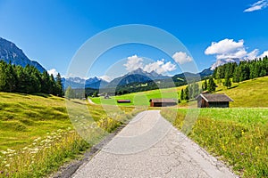 Hay huts and road in the Humpback Meadows between Mittenwald and Kruen, Germany