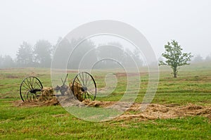 Hay rake in field in fog