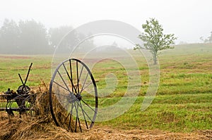 Hay rake in field in fog