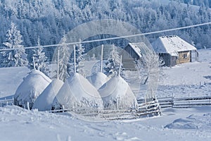 Hay stacks. Winter rural landscape in a mountain village in Transylvania, Romania
