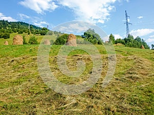 Bevelled hay and haystacks on a mountain slope photo