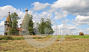 Haymaking near ancient wooden church