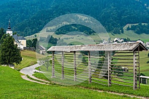 Hayrack on hilltop and Sorica village in Slovenia