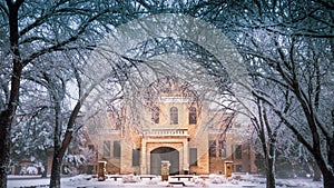 Hays, KS USA - Fort Hays State University`s Picken Hall Front peeking through Snow Covered Tree Branches