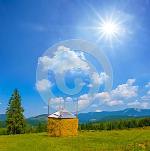 haystack on green mountain pasture at summer day