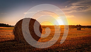 Haystack with the sun setting behind. Haystack in a field in Denmark with the sun setting behind photo