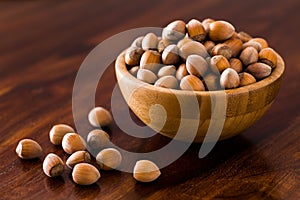 Hazelnut in brown wooden bowl on table