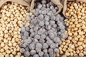 Hazelnut varieties on linen background and linen lathes. Roasted shelled hazelnuts, shelled hazelnuts and shellless roasted