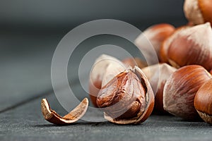 Hazelnuts, filbert on black wooden backdrop. heap or stack of shelled hazelnuts. Hazelnut background, healty food