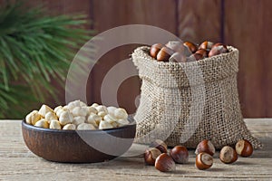 Hazelnuts, filbert in burlap sack and in brown bowl on rustic wooden table. heap or stack of hazelnuts. Hazelnut background, healt