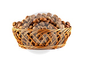 Hazelnuts with leaves in a wooden basket isolated on white background