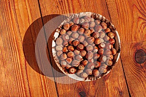 Hazelnuts in porcelain bowl on rustic wooden background. Raw fresh homegrowing nuts from house garden, weight loss diet