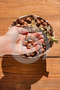 Hazelnuts in porcelain bowl on rustic wooden background. Raw fresh homegrowing nuts from house garden, weight loss diet