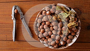 Hazelnuts in porcelain bowl on rustic wooden background. Raw fresh homegrowing nuts from house garden, weight loss diet