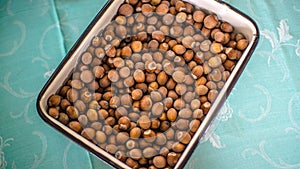 Hazelnuts in the white containers on the blue table