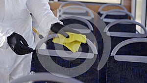 Hazmat team worker disinfects bus interior with antibacterial sanitizer wipes on coronavirus covid-19 quarantine. Man in