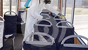 Hazmat team worker disinfects bus interior with antibacterial sanitizer wipes on coronavirus covid-19 quarantine. Man in