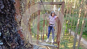 HBH,Palanga, Lithuania -2023:woman solo in adventure park challenging obstacle tracks. Struggle passing physical climbing section