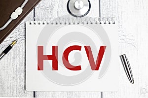 hcv word on white notebook and pen with stethoscope