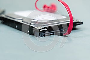 Hdd disk and red sata wire on light background, data storage