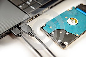 Hdd 2.5 internal hard drive disk connected to laptop via sata usb cable closeup view