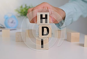 HDI Text Written on Wooden Block and hand