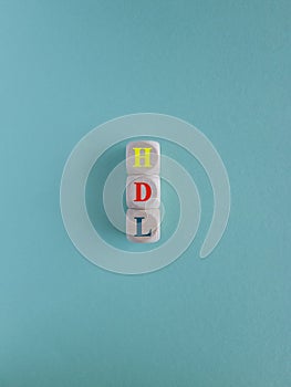 HDL - High-density lipoprotein acronym with marker. Concept words HDL on wooden cubes. Beautiful blue background. Health concept photo