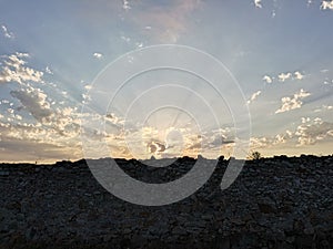 sky illuminated with sun rays through the clouds at sunset