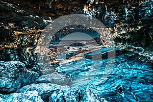 HDR of a cave leading to sea with ice look alike rocks and stalactite