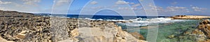 HDR panorama photo of a sunny day at the rocky sea coast with deep blue clean water and small rock formations