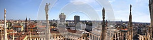 HDR panorama photo of white marble statues of Cathedral Duomo di Milano on piazza, Milan cityscape and the Royal Palace of Milan