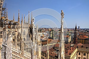 HDR photo of the marble statues and decorations on the Cathedral Duomo di Milano on piazza in Milan and Royal Palace of Milan
