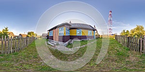 360 hdri panorama view in yard near wooden house in village with mobile communication tower in equirectangular spherical