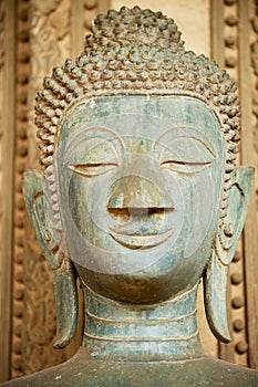 Head of an ancient Buddha statue located outside of the Hor Phra Keo temple in Vientiane, Laos.