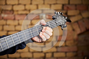 Head of a bass guitar and the fingers of the bassist