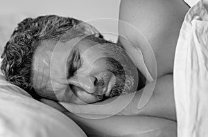 Head on bed close up. Male model sleep in white bed. Sexy shirtless man sleep in bed at bedroom. Hispanic mature man