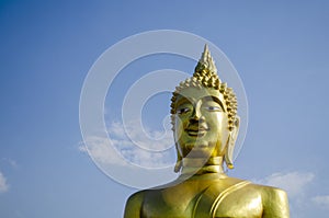 Head of the Big Buddha statue against a blue clear sky, copy space