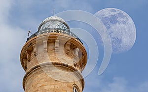 The head of the big Chipiona lighthouse on the day with the moon in the sky. photo
