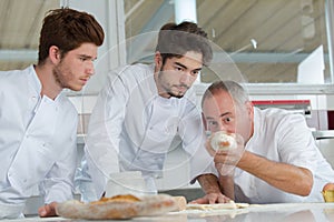 Head chef with apprentices in kitchen