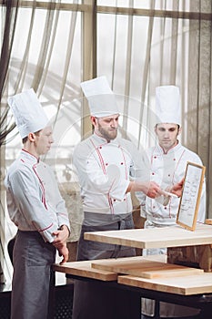 Head Chef and his staff in kitchen. interacting to in commercial kitchen