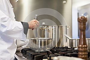 Head chef stirring in pot