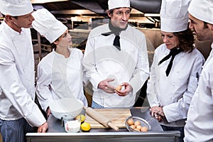Head chef teaching his team to prepare a dough