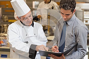 Head chef and waiter discussing menu